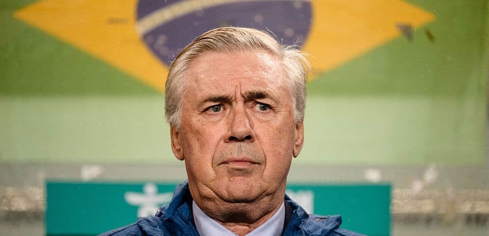 Entrenador en la zona técnica con bandera de Brasil