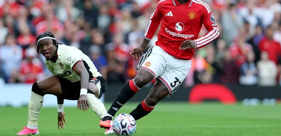 Jugador de Manchester United driblando a oponente en partido