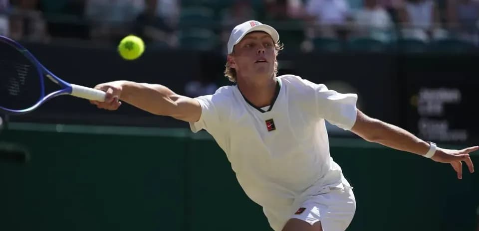 Jugador de tenis alcanzando una pelota en la cancha