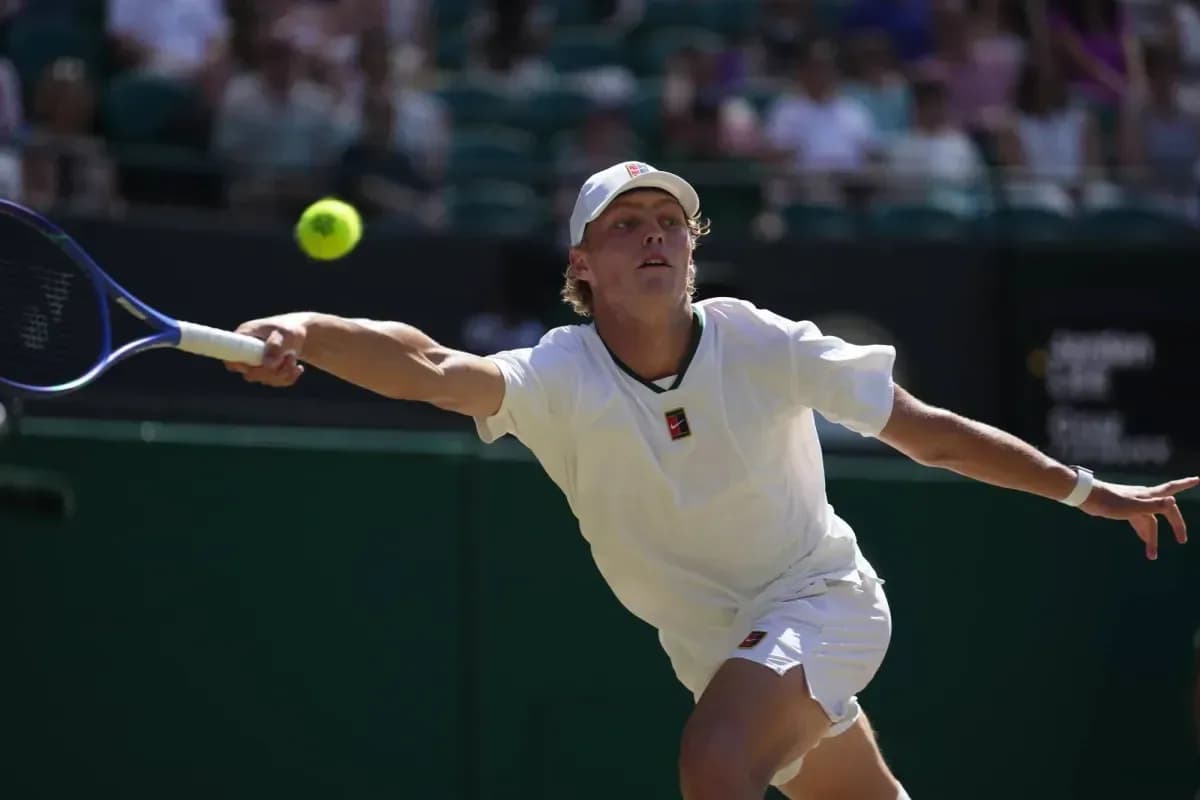 Jugador de tenis alcanzando una pelota en la cancha