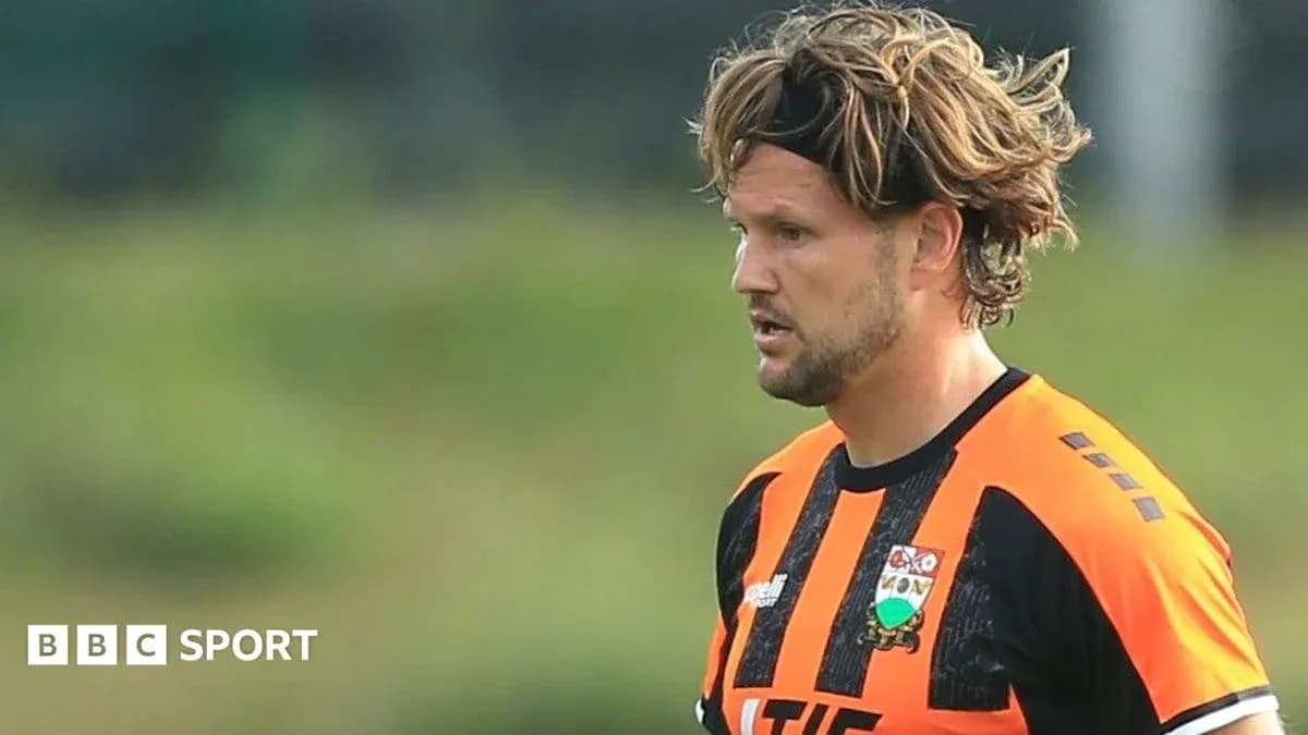 Jugador con camiseta naranja y negra en el campo