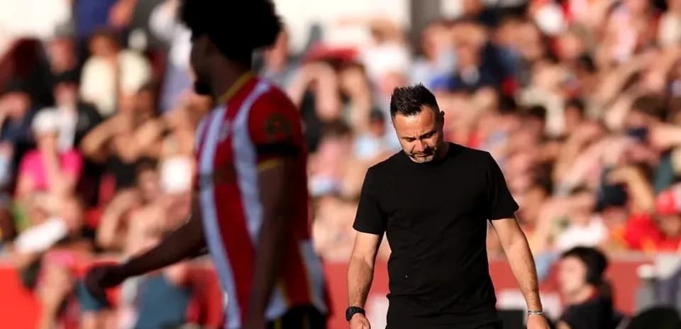 Entrenador caminando por el campo durante el partido