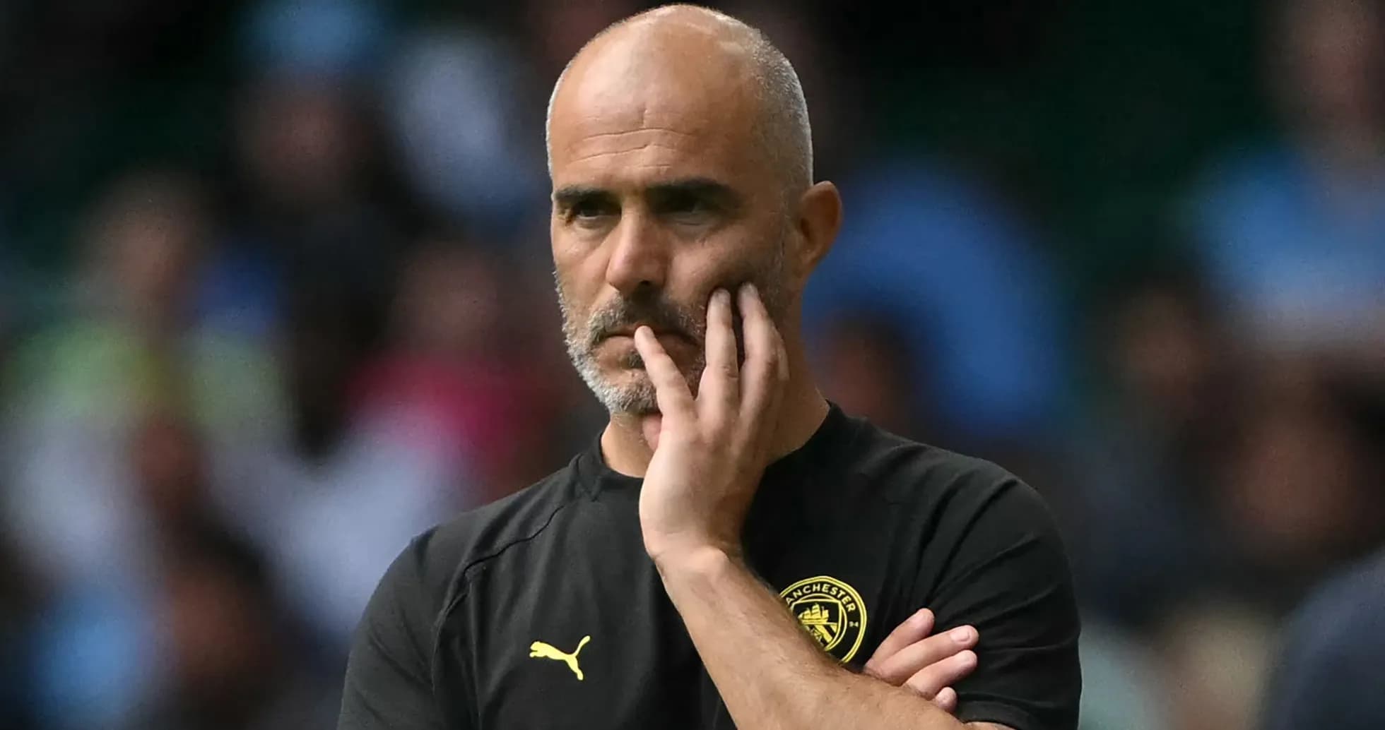 Entrenador observando el partido con expresión pensativa