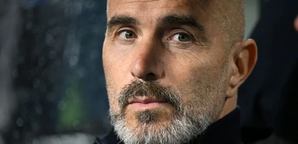 Entrenador con barba sentado en el banquillo