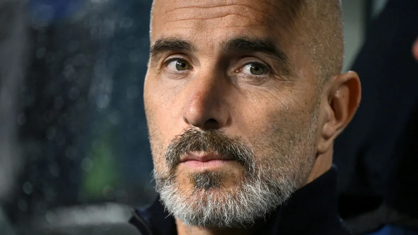 Entrenador con barba sentado en el banquillo