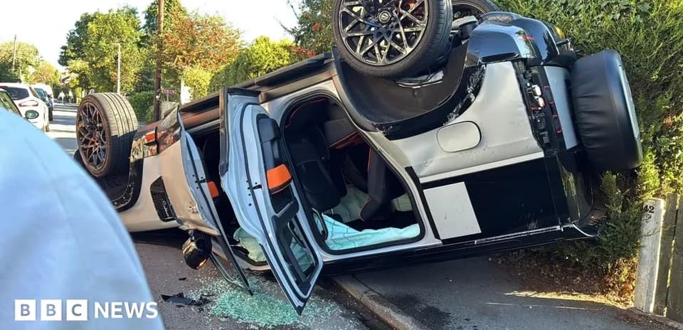 Coche volcado en la calle con cristales rotos