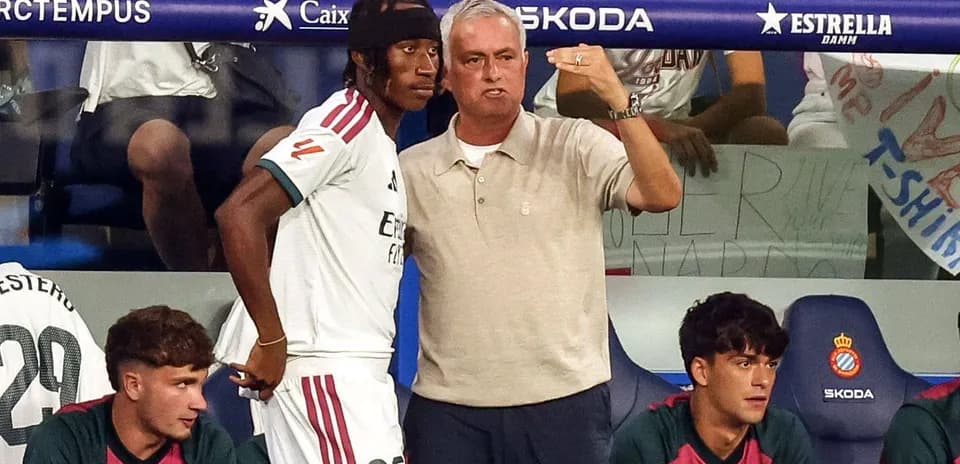 Entrenador hablando con jugador en el banquillo