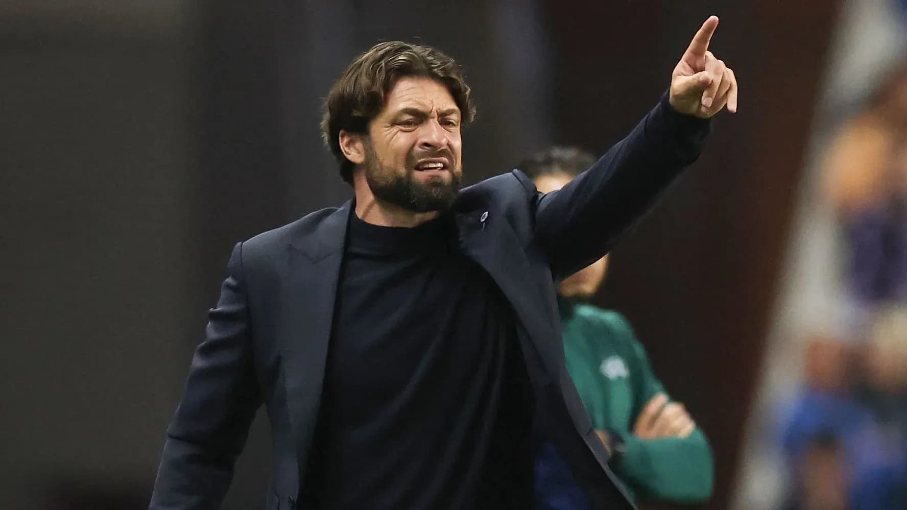Entrenador dirigiendo instrucciones durante el partido