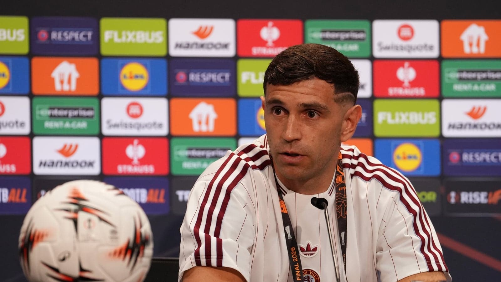 Jugador hablando en conferencia de prensa con balón
