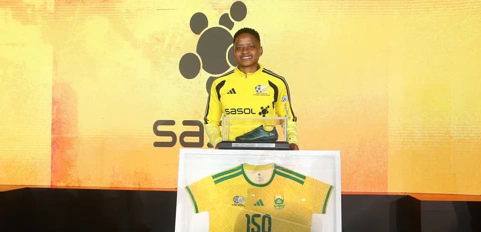 Jugador sosteniendo botas y camiseta en evento