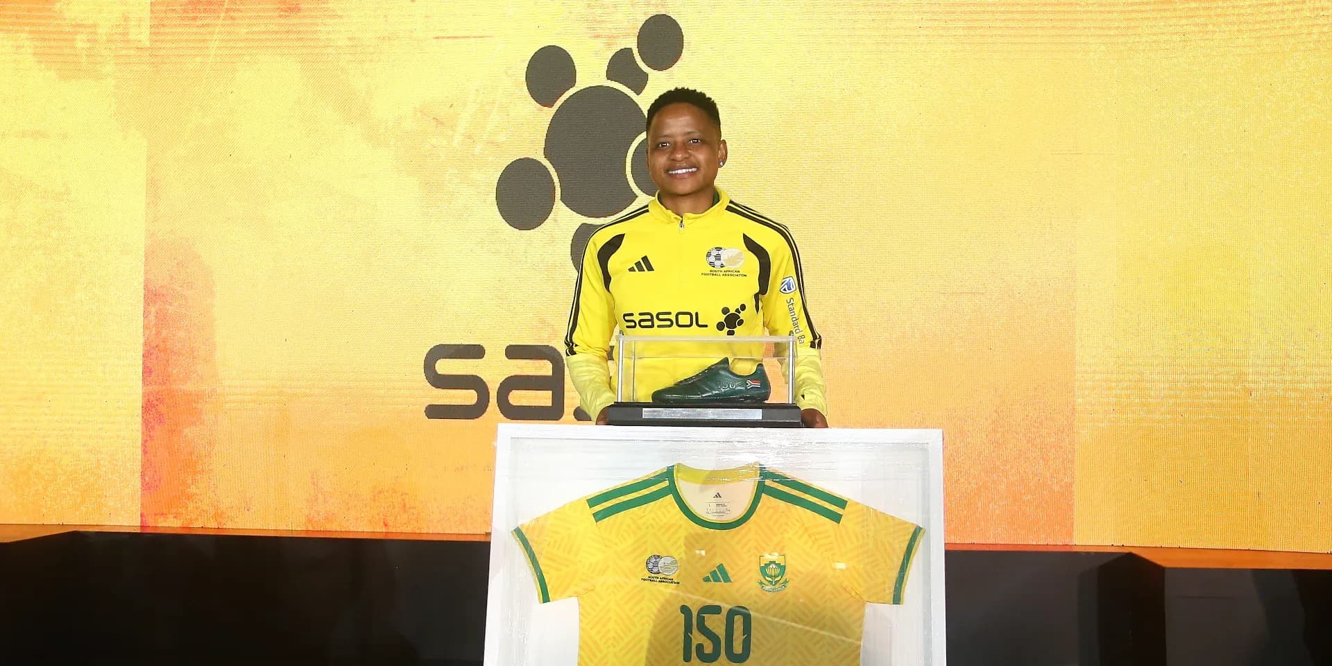 Jugador sosteniendo botas y camiseta en evento
