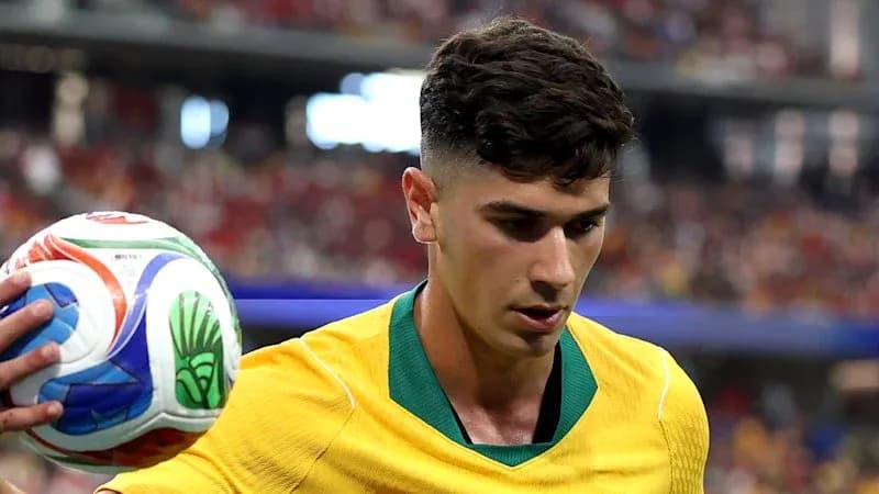Jugador australiano sosteniendo un balón de fútbol