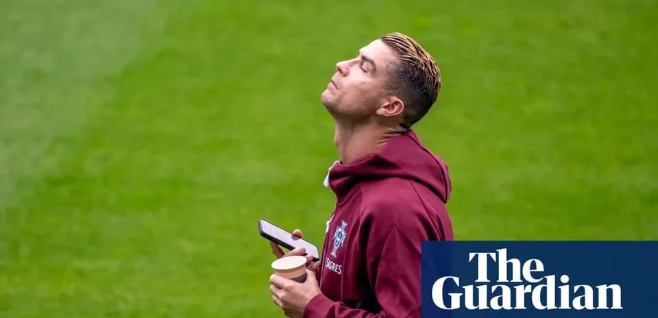 Jugador sosteniendo un teléfono y un café en campo