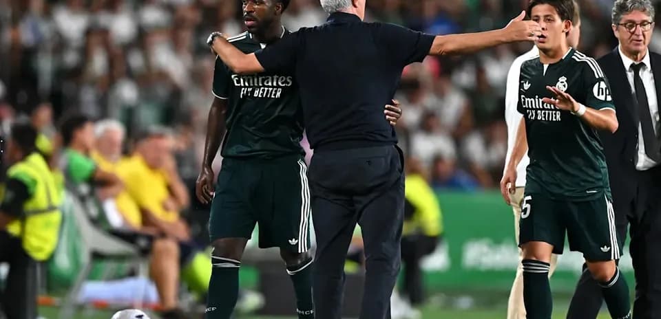 Entrenador hablando con jugadores de Real Madrid en el banquillo