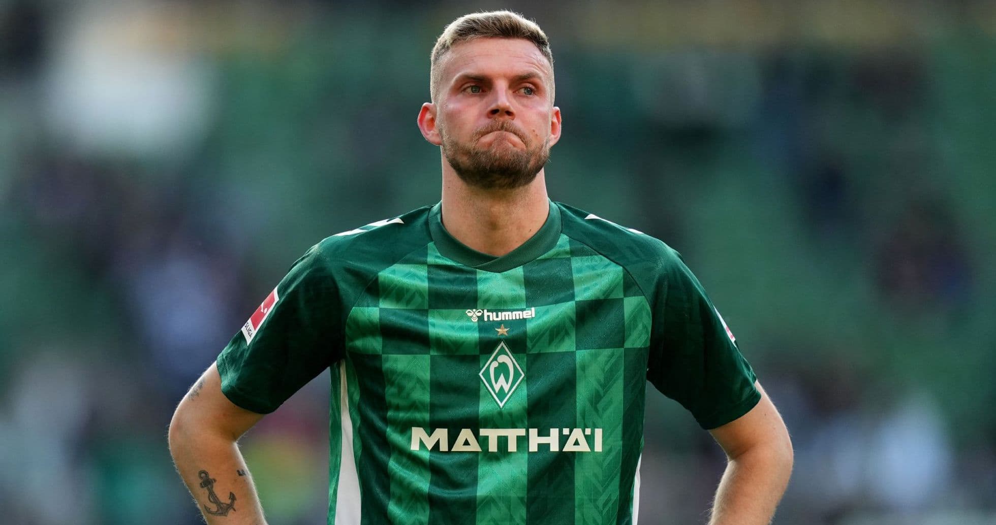 Jugador de Werder Bremen en uniforme verde en el campo