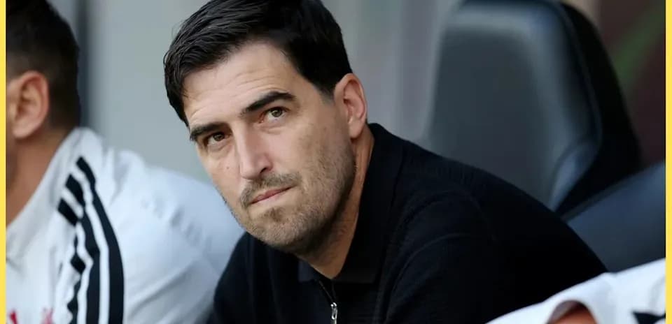Entrenador observando el partido desde el banquillo