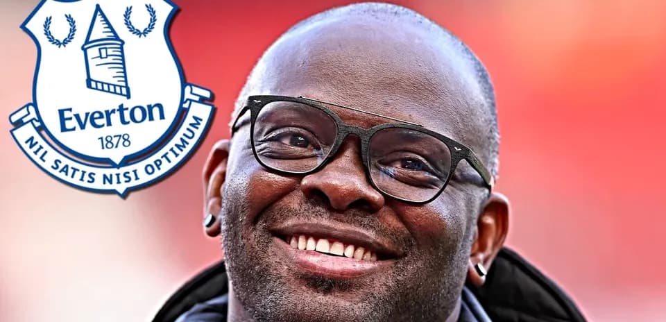 Hombre sonriendo con gafas junto al logo de Everton