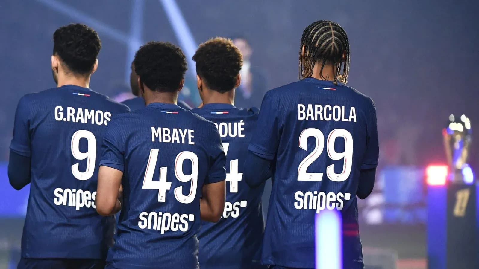 Jugadores de fútbol con camisetas de espaldas en el campo