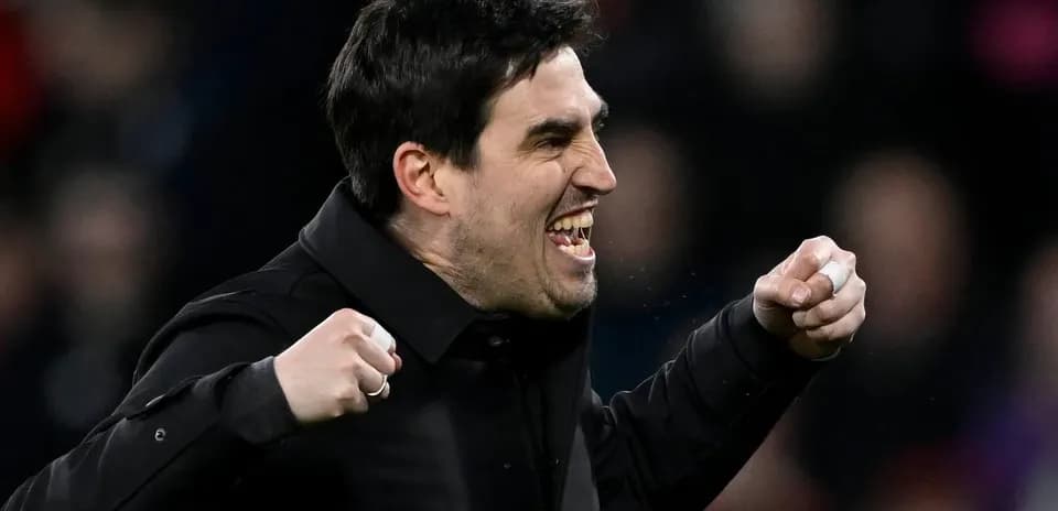 Entrenador celebrando con puños en alto