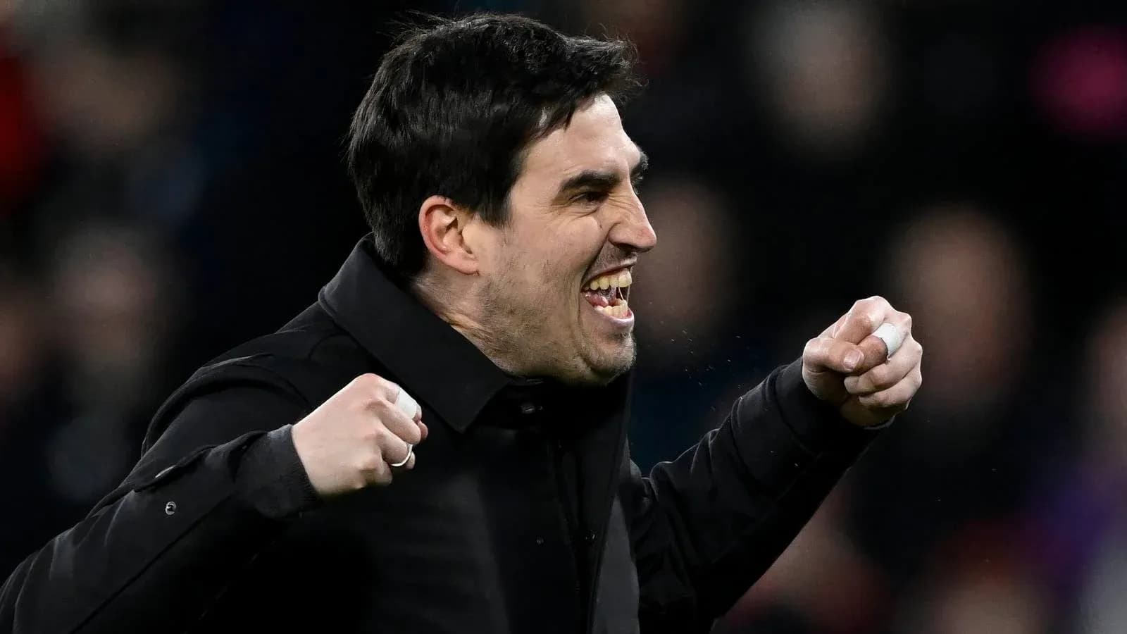 Entrenador celebrando con puños en alto