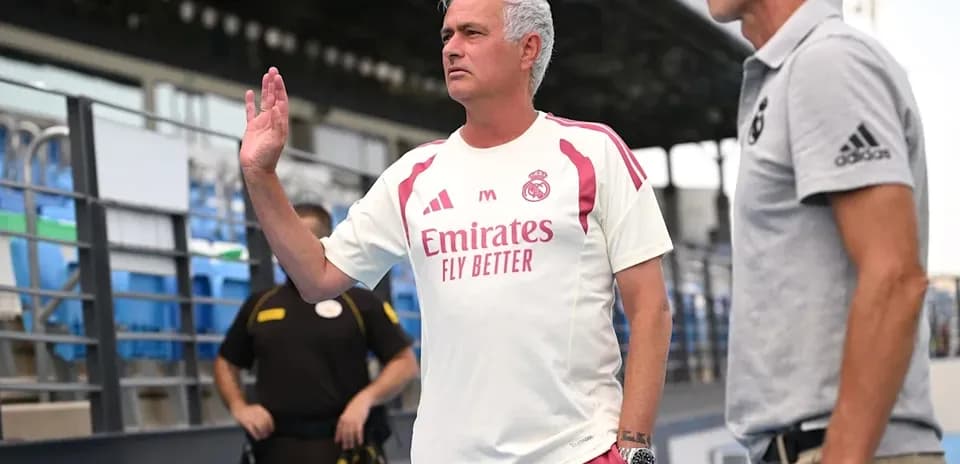 Entrenador de Real Madrid saludando en el banquillo