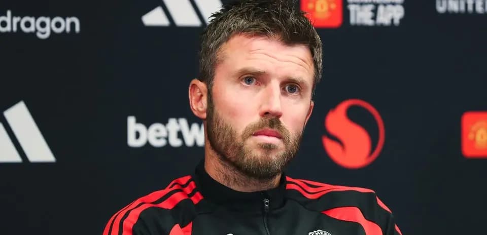 Entrenador en rueda de prensa con logo de Manchester United