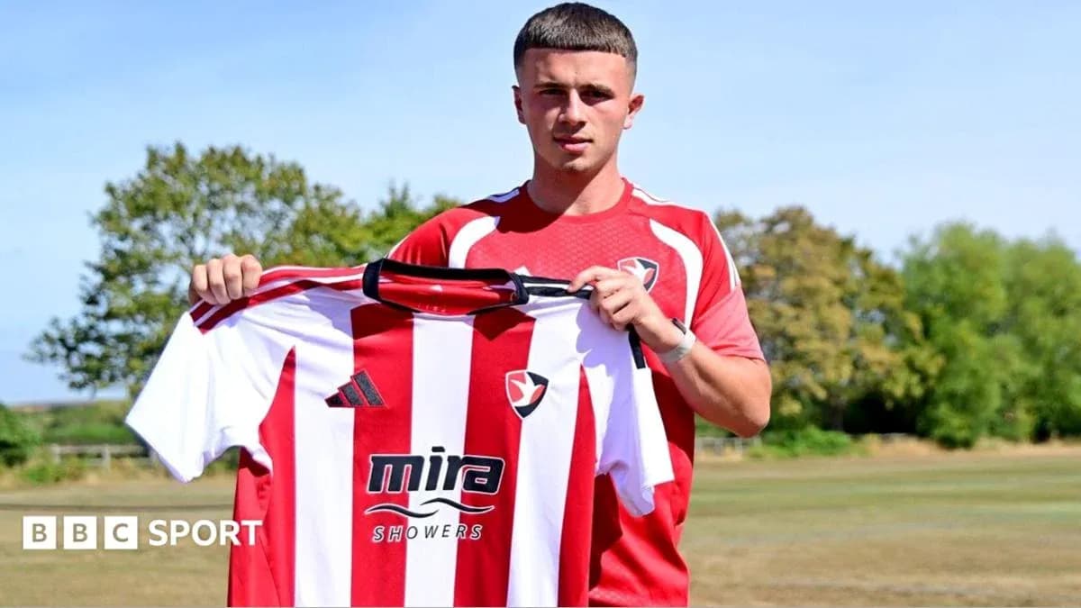 Jugador sosteniendo camiseta de Cheltenham Town FC