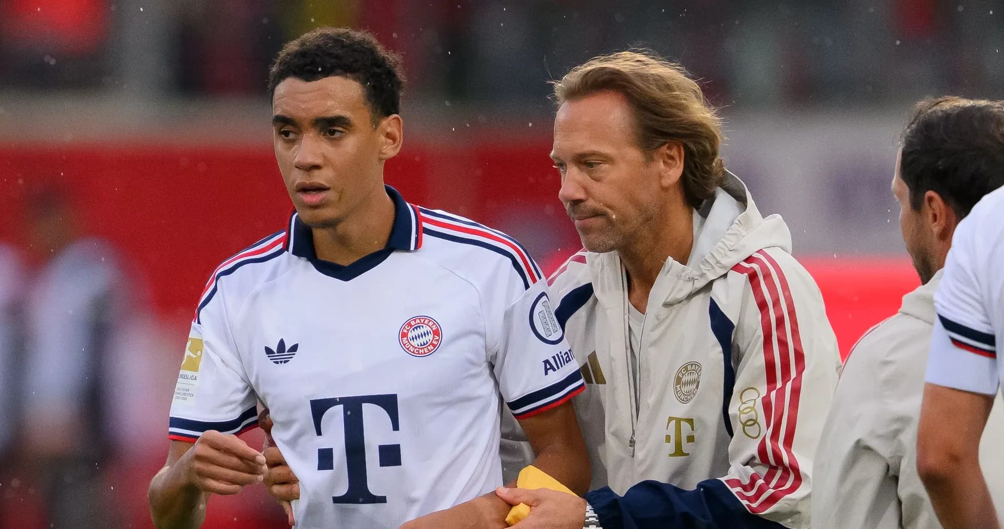 Jugador de Bayern Múnich siendo atendido por entrenador