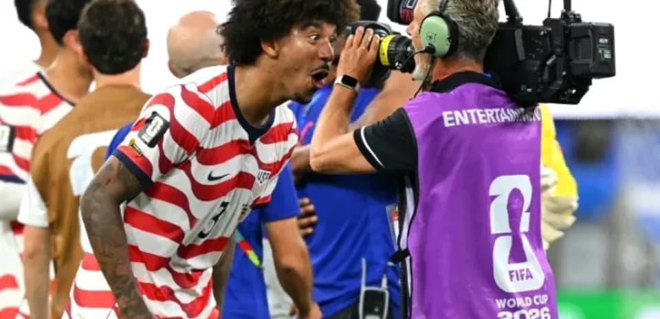 Jugador de EE. UU. celebrando con camarógrafo tras partido