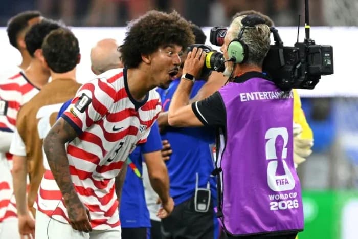 Jugador de EE. UU. celebrando con camarógrafo tras partido