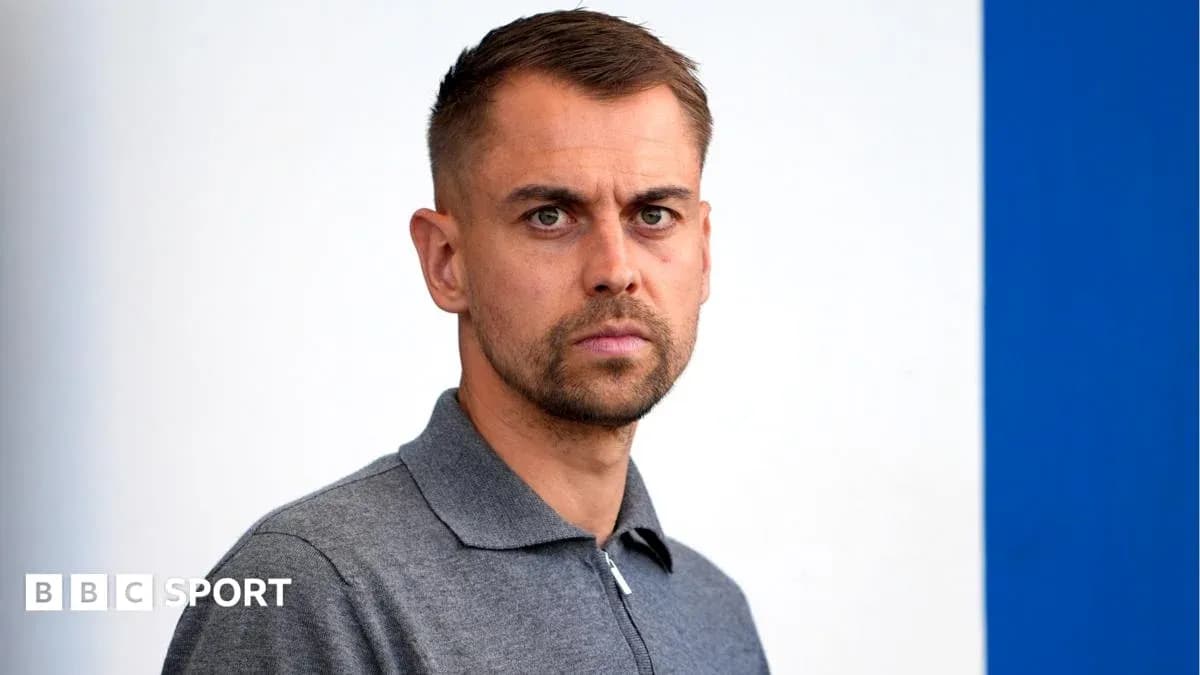 Hombre con camiseta gris frente a fondo blanco y azul