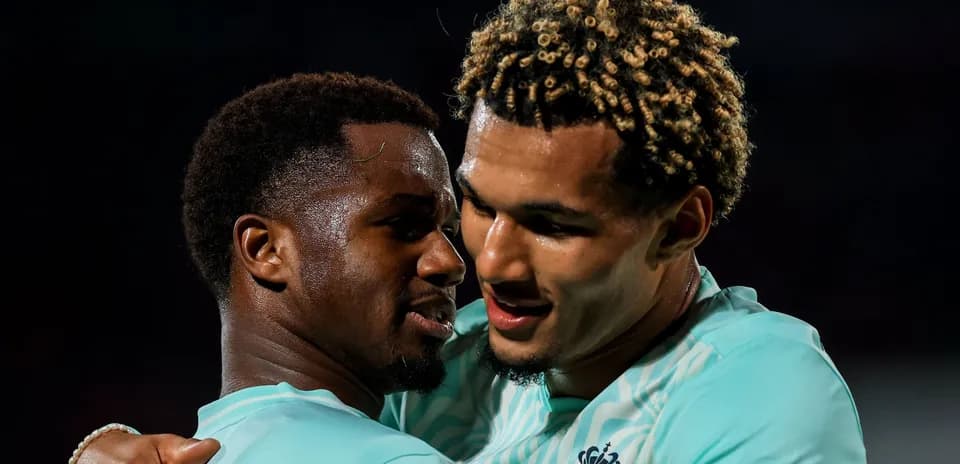 Dos jugadores celebrando en el campo de fútbol