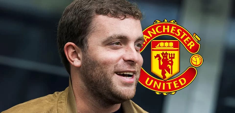 Persona sonriendo frente al logo de Manchester United