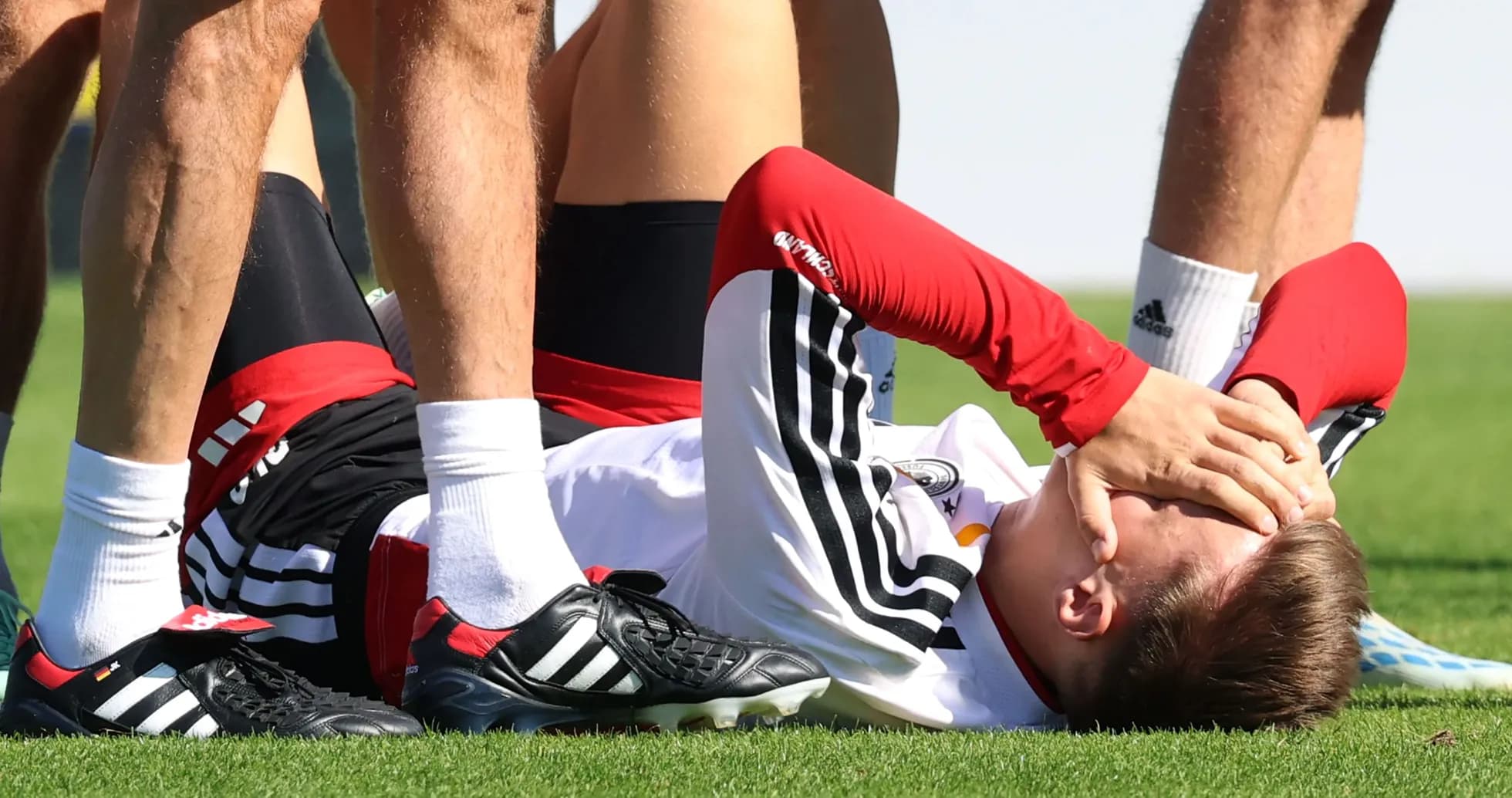 Jugador en el suelo con las manos en la cara