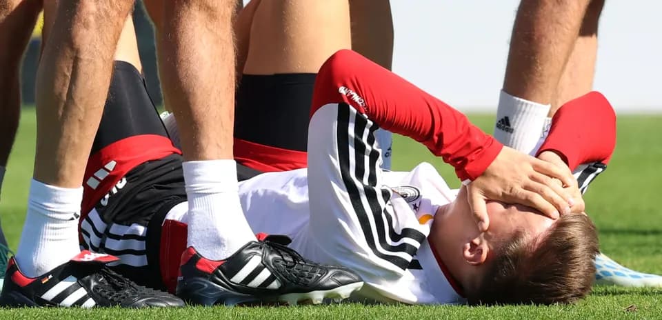 Jugador en el suelo con las manos en la cara