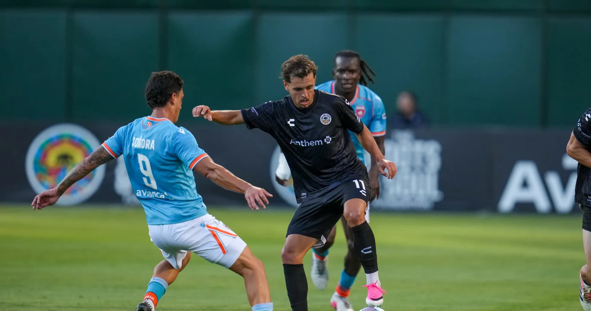 Jugador de Miami FC desafiando a rival de Oakland Roots