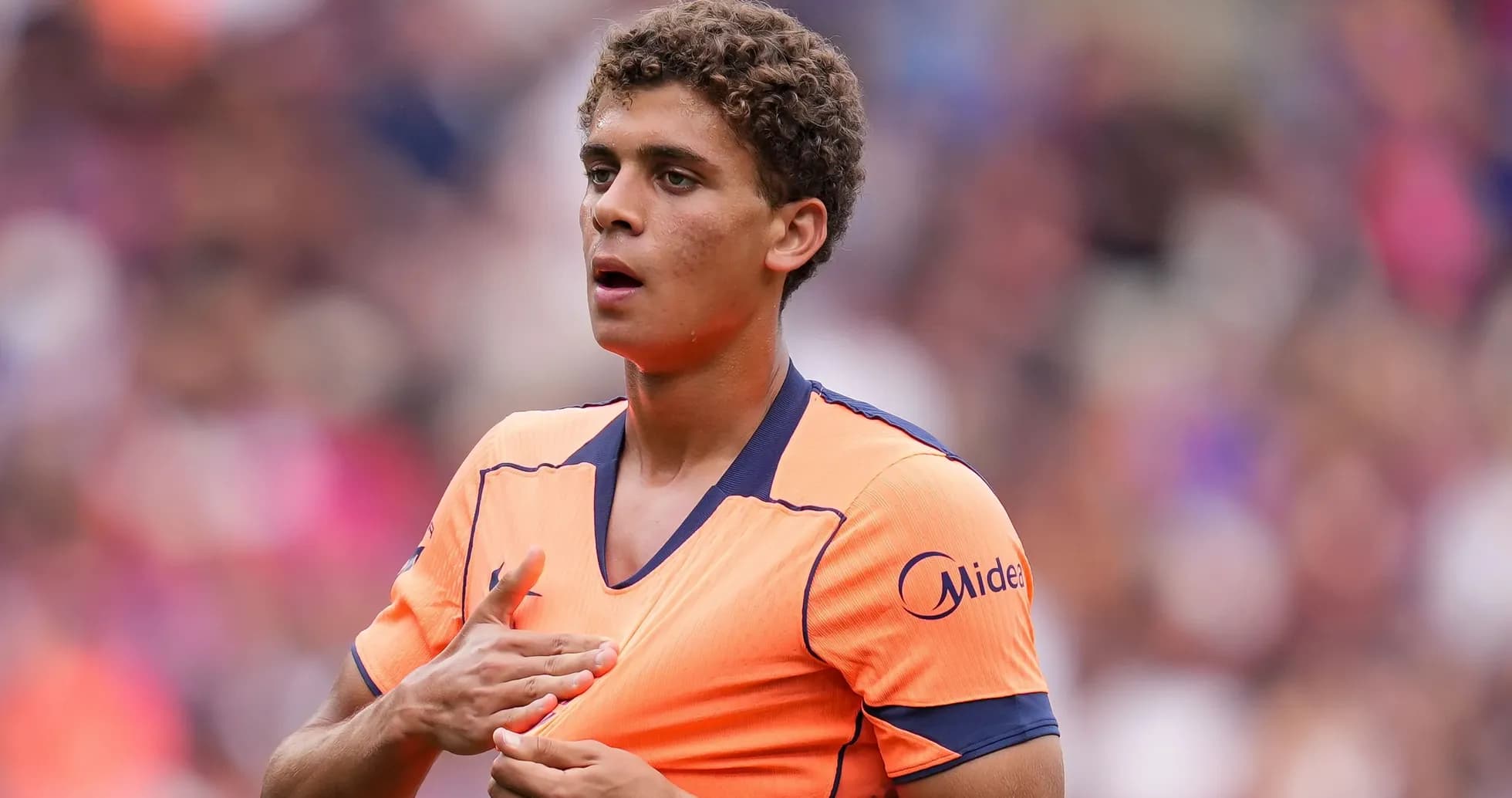 Jugador de fútbol ajustando su camiseta en el campo