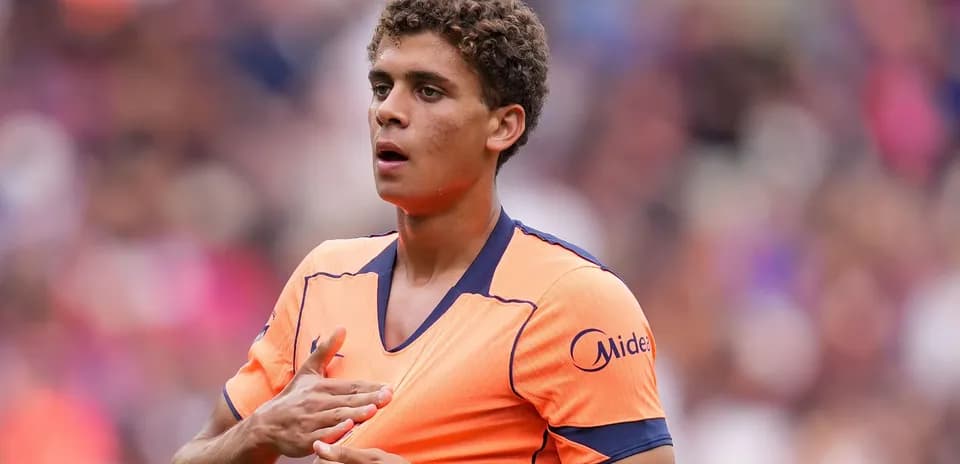 Jugador de fútbol ajustando su camiseta en el campo