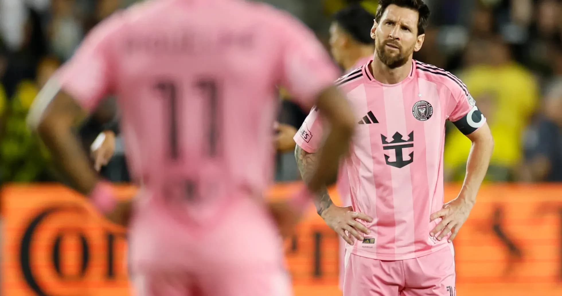 Lionel Messi y compañero en partido con camiseta rosa
