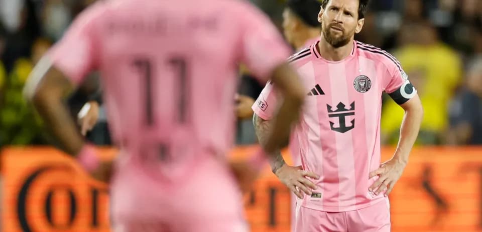 Lionel Messi y compañero en partido con camiseta rosa