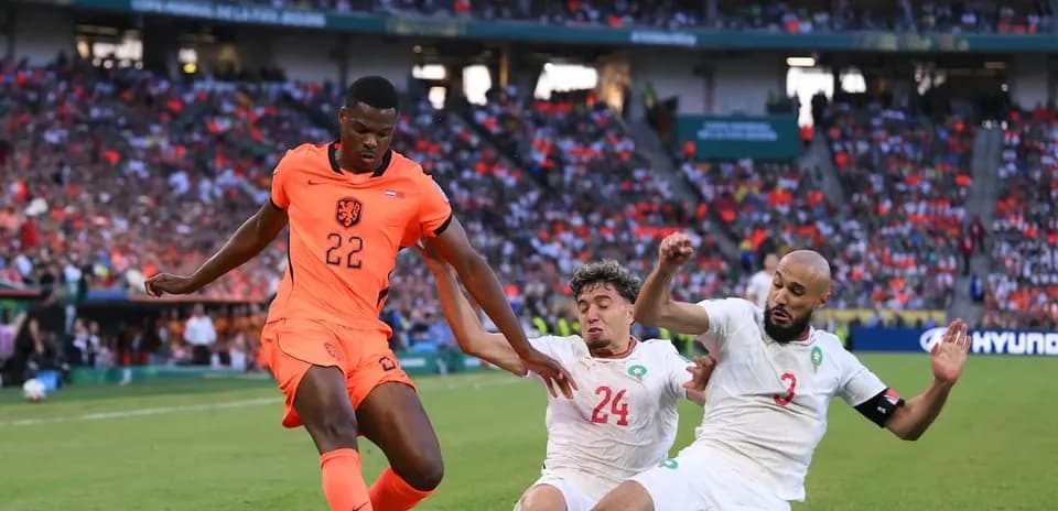 Jugador de Países Bajos esquivando a dos rivales