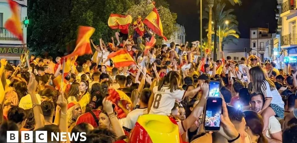 Multitud celebrando con banderas en la calle