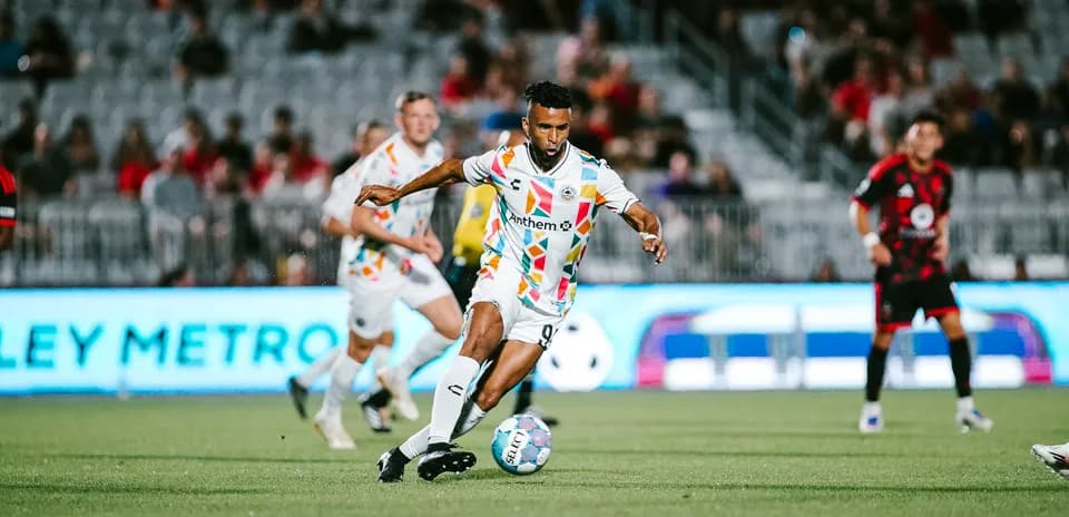 Jugador de Phoenix Rising driblando en el campo