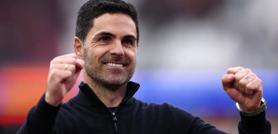 Entrenador sonriendo y levantando los puños en celebración