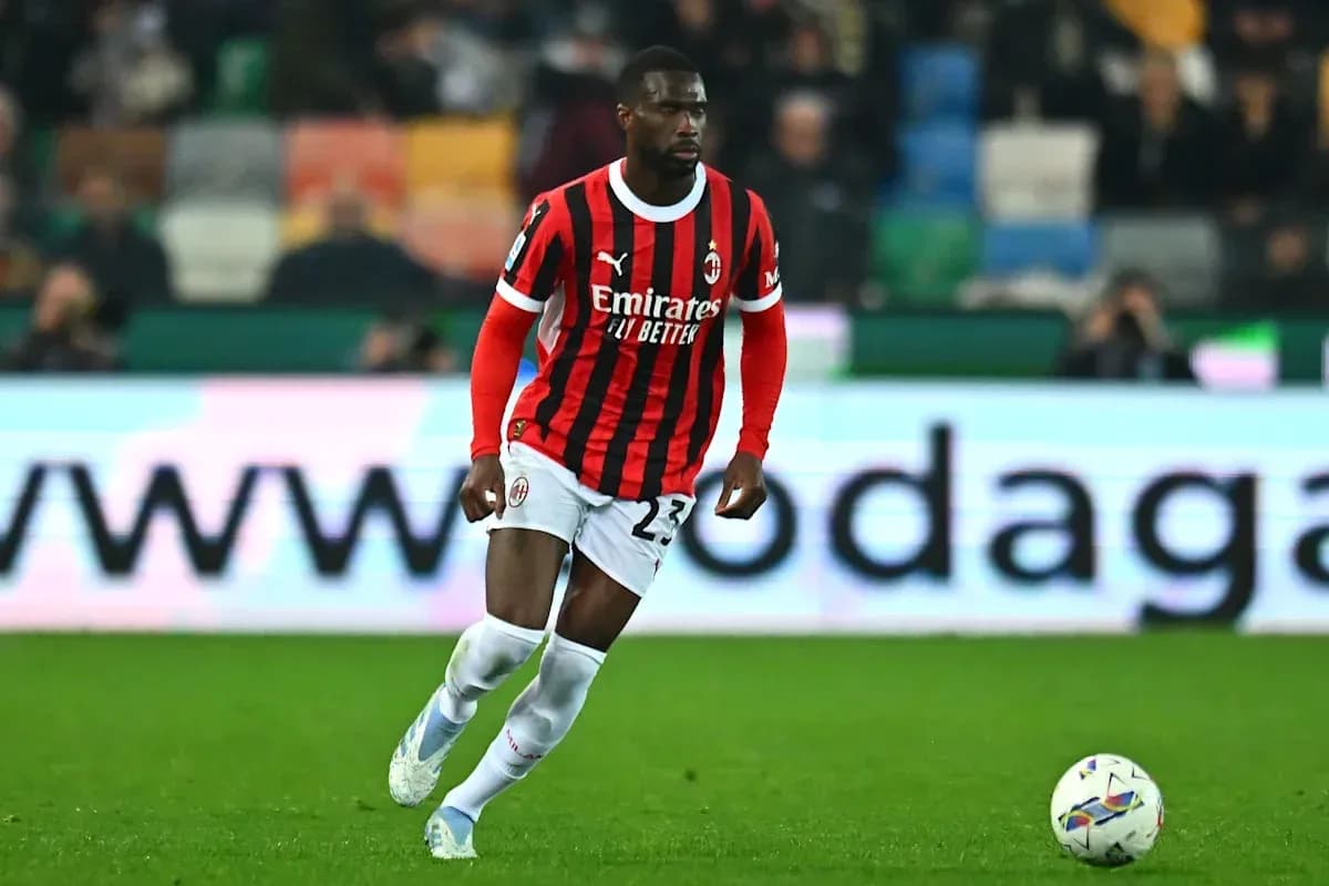 Jugador de AC Milan corriendo con balón en el campo