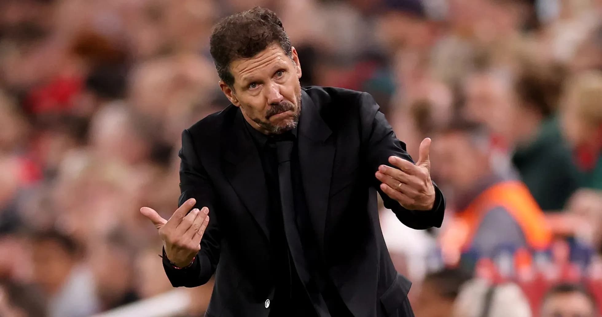Entrenador gesticulando durante un partido de fútbol