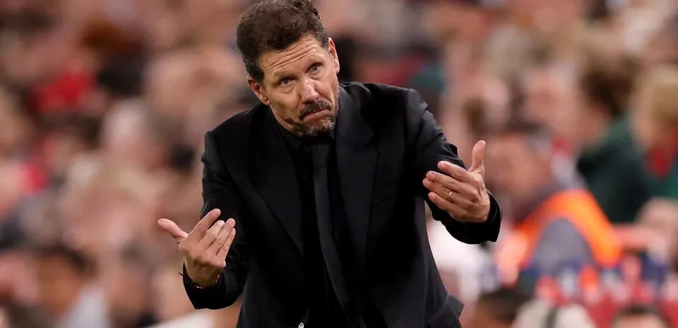 Entrenador gesticulando durante un partido de fútbol