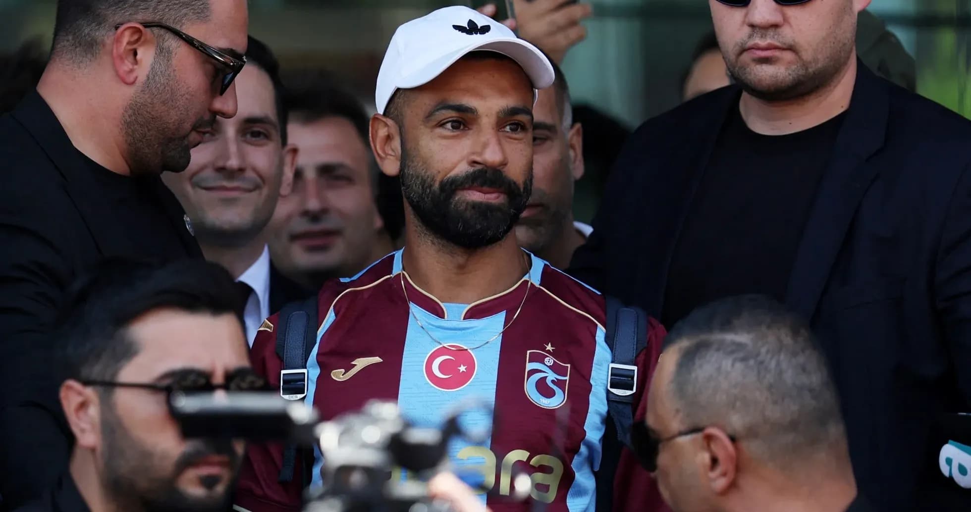 Jugador con camiseta de Trabzonspor rodeado de seguridad