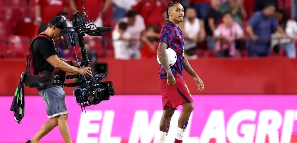 Jugador con balón y camarógrafo en el campo
