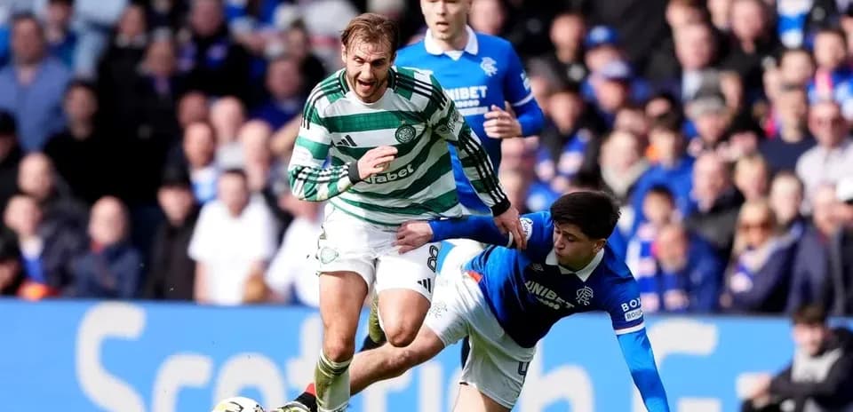 Jugador de Celtic esquivando a un oponente de Rangers